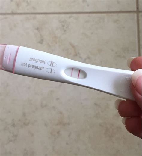 Nosečnica gleda pozitiven nosečniški test