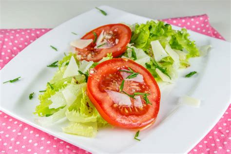 Fotografija sveže pripravljene solate s paradižnikom, kumarami, papriko in zeleno solato, začinjene z olivnim oljem.