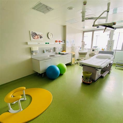 Ženska sedi na gimnastični žogi v porodni sobi