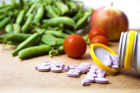 različni vitamini in minerali v obliki tablet in živil