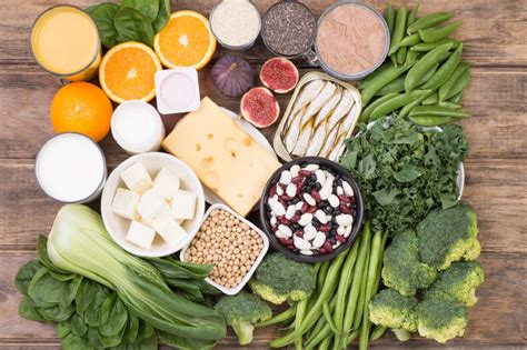 Diagram prikazuje različna živila, razvrščena po vsebnosti kalcija, z izpostavljenimi mlečnimi izdelki, zeleno listnato zelenjavo, stročnicami in oreščki.