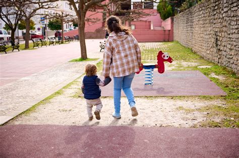Starši držijo otroka za roko na sprehodu