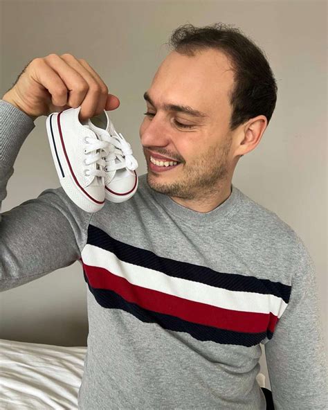 Par, ki drži otroške copatke.