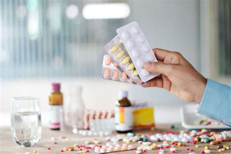 Ženska, ki ima v roki škatlico zdravil in tablete