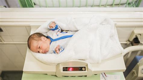 Novorojenček spi v postelji ob starših