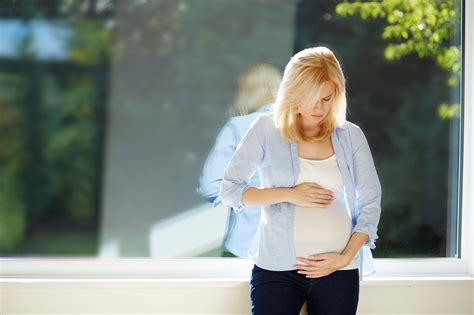 Nosečnica, ki se gleda v ogledalo in se počuti samozavestno