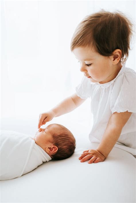 Simbolična fotografija novorojenčka v naročju staršev.