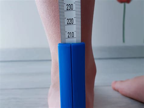 Otrok, ki stoji na papirju za merjenje stopala