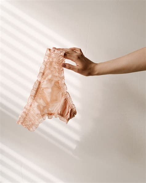 Ženska, ki opazuje rjav izcedek na toaletnem papirju