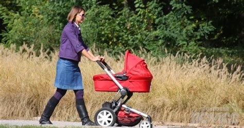 Mama z otroškim vozičkom v mestnem parku