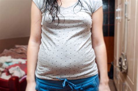 Ilustracija ženske z velikim nosečniškim trebuhom, ki ima pogoste potrebe po uriniranju