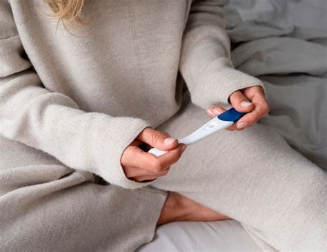 Ženska, ki drži v rokah test nosečnosti