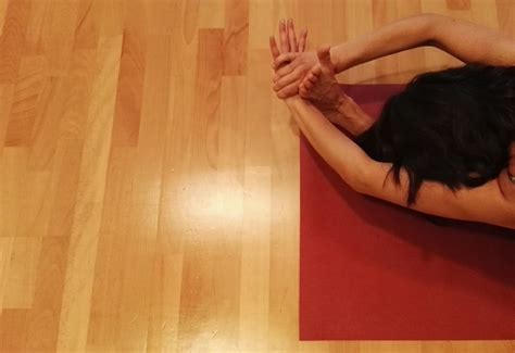 Nosečnica v sproščujočem položaju med joga vadbo.