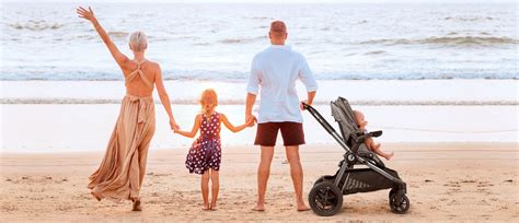 Družina na plaži s senčnikom in otrokom v plitvini