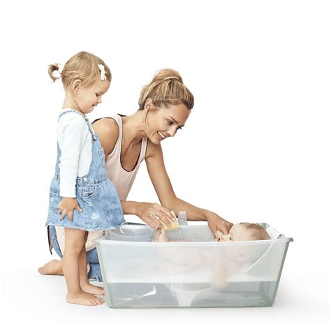 Dojenček se igra v banjici Stokke Flexi Bath XL z ergonomskim nastavkom za novorojenčke.