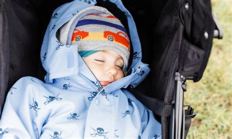 Otrok, ki spi v topli zimski vreči v vozičku