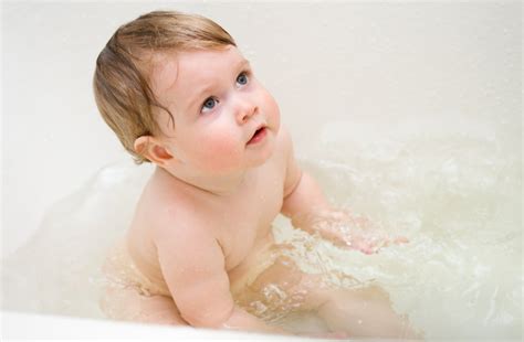 Starš kopati dojenčka v otroški banjici