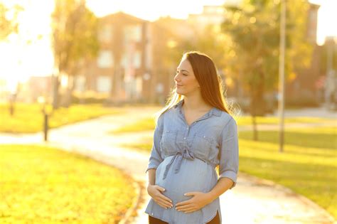 Nosečnica uživa na sprehodu po sončnem travniku
