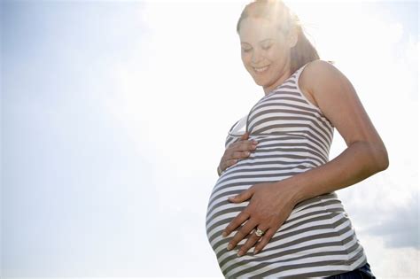 Nosečnica v mirnem okolju, ki se dotika svojega trebuha