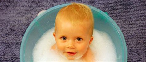 dojenček z mokro krpico čisti dlesni