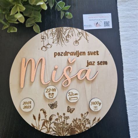 Lesena štorklja z izpisanim imenom in rojstnimi podatki otroka.