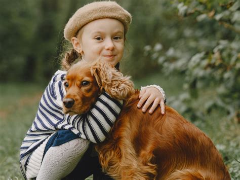 Otrok in pes, ki se igrata, simbolizirata varen odnos