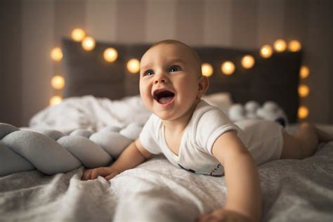 Dojenček leži na trebuhu in se opira na roke