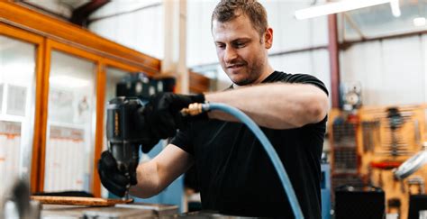 Delavec v varnostni opremi, ki pregleduje strojno opremo