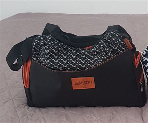 Ženska z elegantno previjalno torbo LÄSSIG