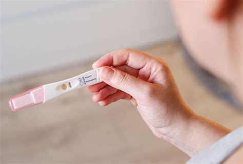 Ženska drži v roki nosečniški test