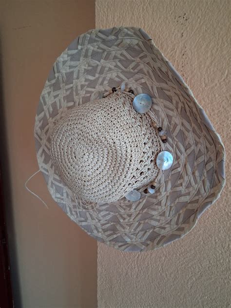 Nosečnica, ki si nanaša zaščitno kremo proti soncu in nosi klobuk