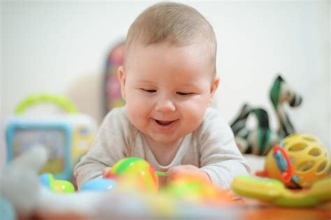 Dojenček s slinčkom, ki se igra z igračo