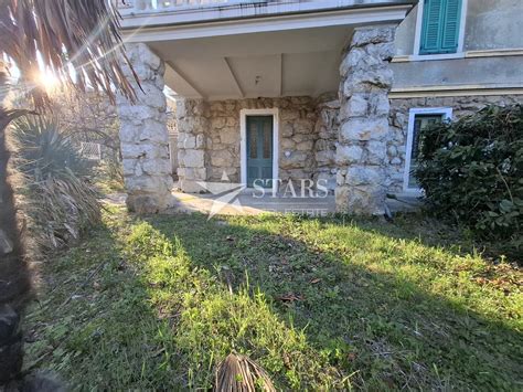 Nosečnica v zlati uri ob morju, s silhueto osvetljeno s sončnim zahodom.