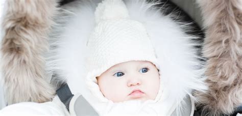 Starš z dojenčkom v nosilki pozimi