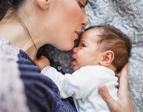 mamica se smehlja dojenčku med previjanjem