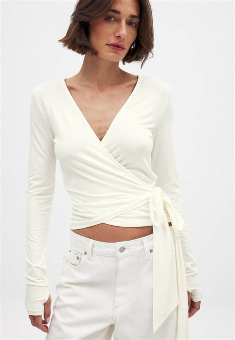 Ženska v obleki na preklop, ki poudarja dekolte in skriva trebuh.