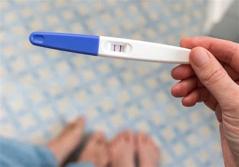 Nosečnica drži v roki test nosečnosti