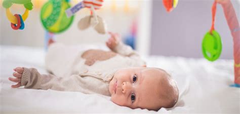 Dojenček, ki se igra na stegnih starša