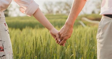 Nosečnica in njen partner, ki držita skupaj skupaj roke.