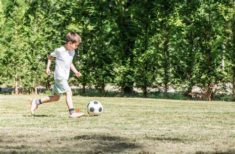 Otrok igra nogomet, ampak večino časa uporablja samo eno nogo