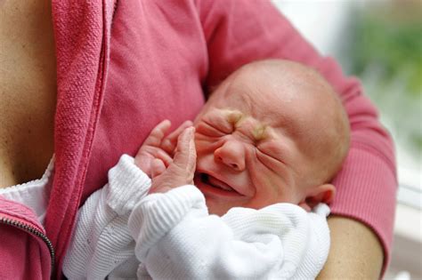 Prikaz dojenčice, ki jo nežno drži mati