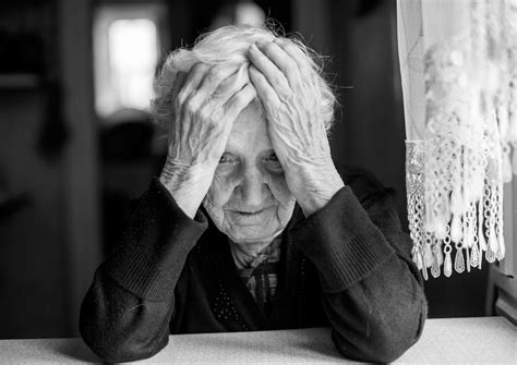 žena, ki se drži za glavo