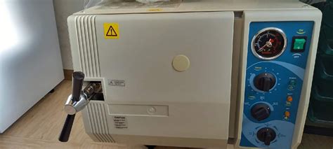 Notranjost inkubatorja z nedonošenčkom in medicinsko opremo.