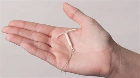 Ženska, ki drži v roki maternični vložek Mirena