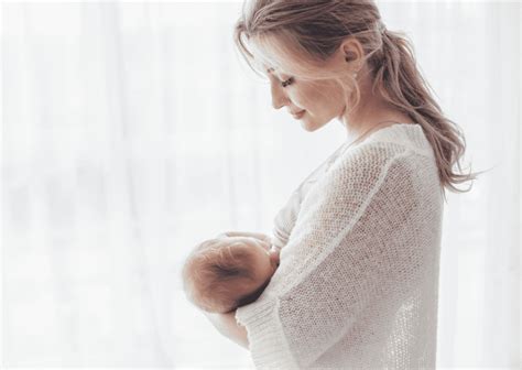 Mamica, ki drži zadovoljnega dojenčka