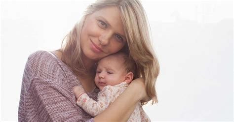 Ženska, ki drži novorojenčka po carskem rezu.