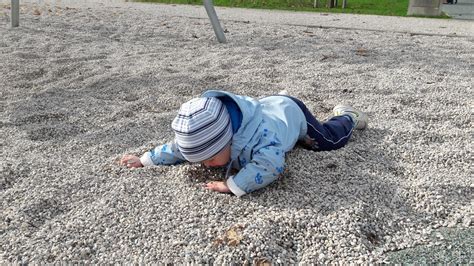 Otrok leži na hrbtu, oseba stoji nad njim in preverja njegovo odzivnost.