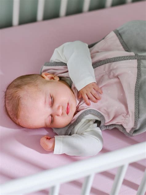 Novorojenček spi v otroški posteljici