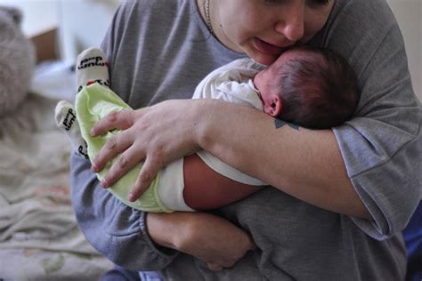 Ženska, ki drži svojega novorojenčka