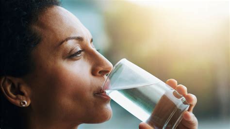 žena pije vodo iz steklenice